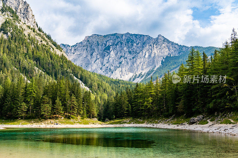 Grüner See (Green Lake) -奥地利的山湖，被松树林和巨大的山脉包围。蓝色多云的天空在背景上。